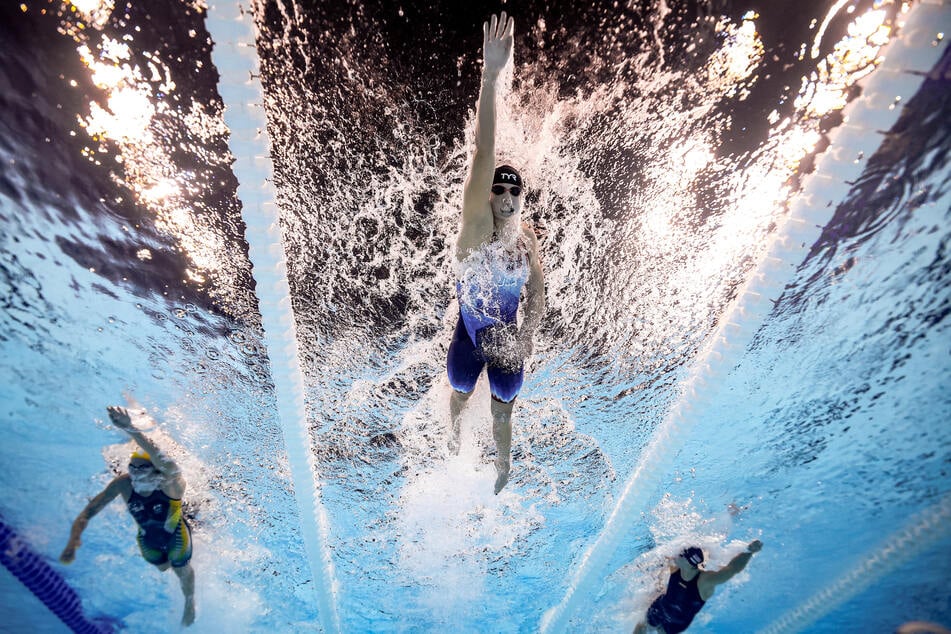 Katie Ledecky of United States (c.), Ariarne Titmus of Australia (l.), and Paige Madden of United States in action during the women's 800m freestyle race at the Paris Olympics.