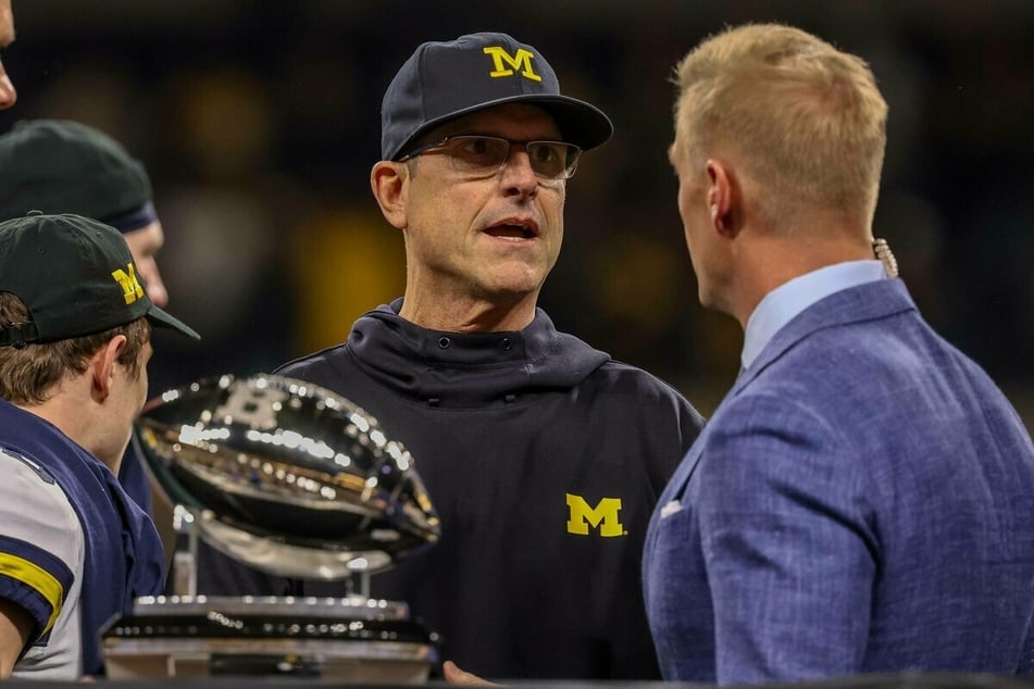 Wolverines head coach Jim Harbaugh (c) received the Big Ten Championship trophy.