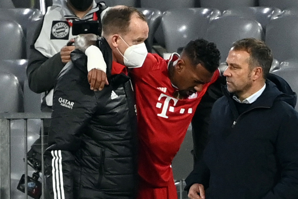 Münchens Abwehrspieler Jerome Boateng (M.) wird verletzt vom Platz geführt.