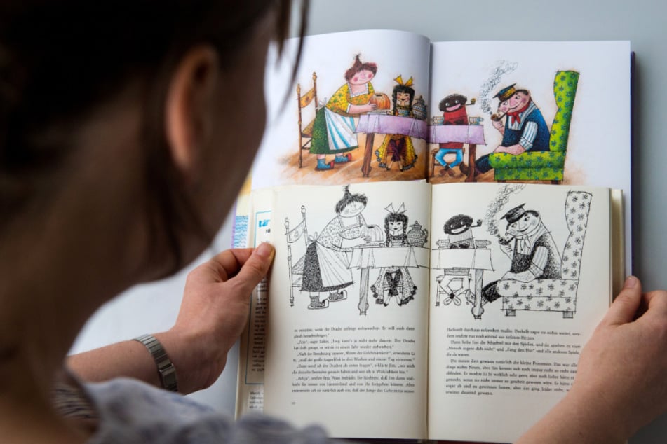 Eine Frau hält in Stuttgart eine alte (vorn) und eine neue Ausgabe des Kinderbuchs "Jim Knopf und die wilde 13" des Autors Michael Ende in den Händen.