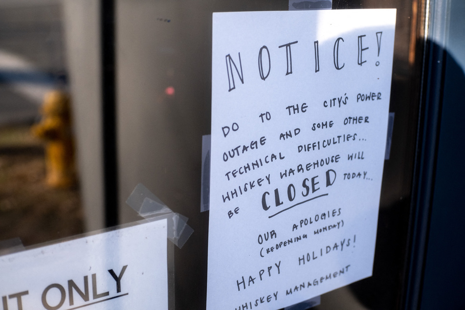 A sign advises a bar closure hangs due to widespread power outages in the Plaza Midwood neighborhood in Charlotte, North Carolina.