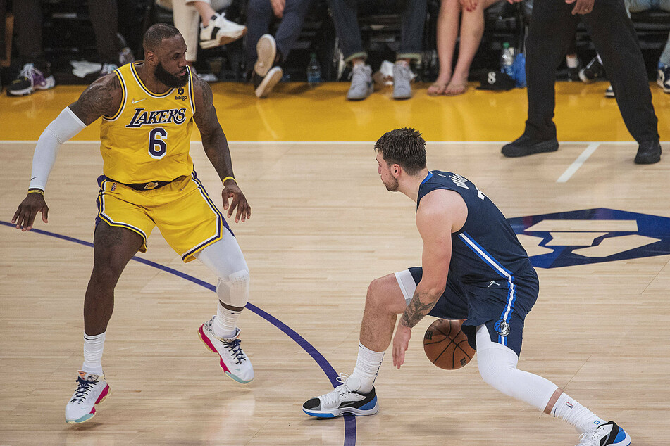 Luka Doncic (r.) goes up against LeBron James during the Mavericks' win over the Lakers.