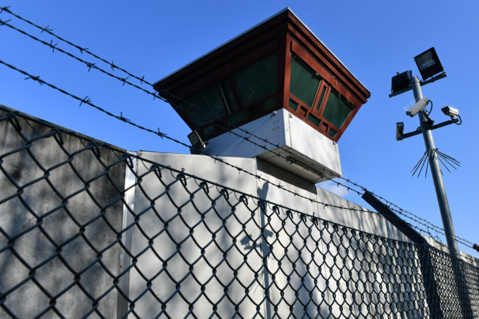Sicherheitsleuchten und Überwachungskameras sind vor einem Gebäude auf dem Gelände der Justizvollzugsanstalt Tegel zu sehen.