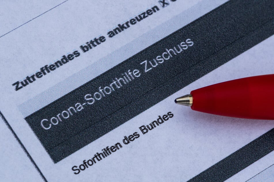 Ein Stift liegt auf einem Antrag für den Corona-Soforthilfe-Zuschuss.