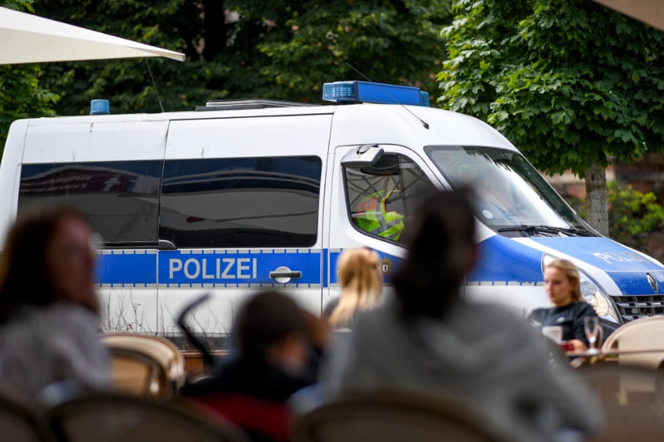 Ein Einsatzfahrzeug der Polizei fährt an einem Lokal am Alexanderplatz vorbei.