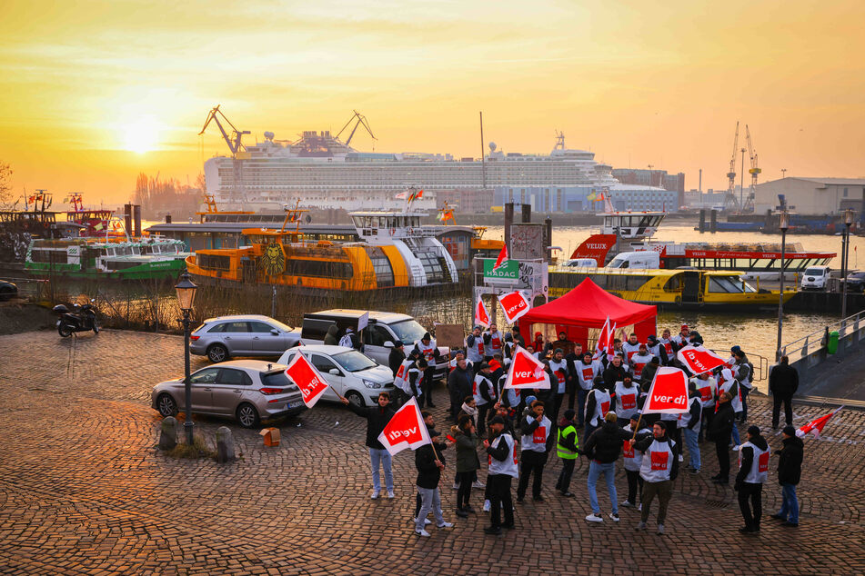 Streikposten Mitte Februar im Hamburger Hafen. Im Hintergrund ein Kreuzfahrtschiff in den Docks von Blohm+Voss.