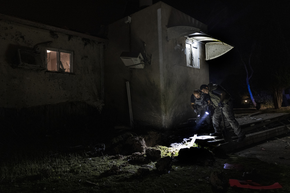 Israelische Polizisten inspizieren den Schaden an einem Haus, das von einem aus dem Gazastreifen abgefeuerten Raketenwerfer getroffen wurde, in einem Kibbuz nahe der Grenze zwischen Israel und dem Gazastreifen.