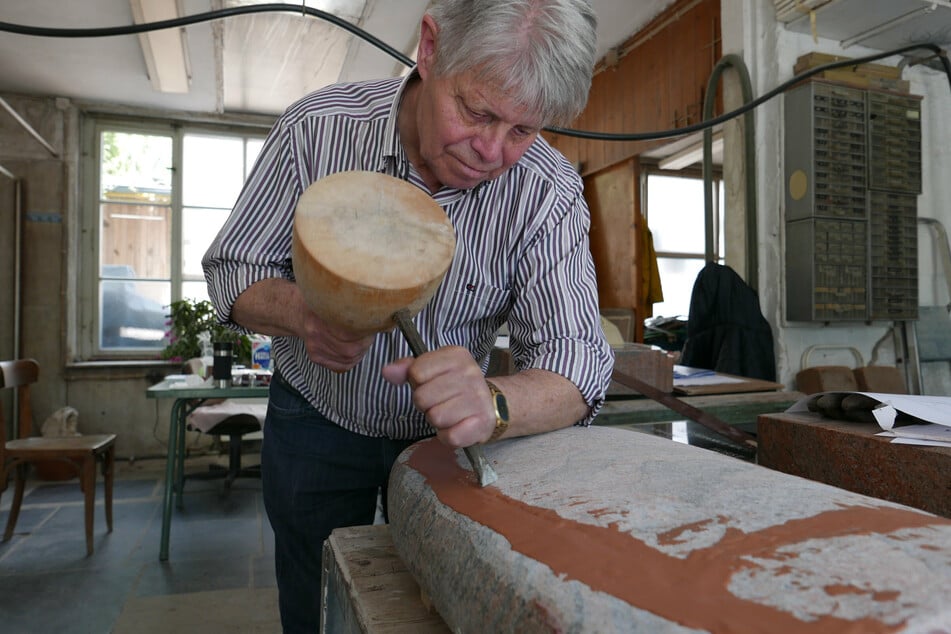 Eberhard Damerau (76) bei der Arbeit mit Knüpfel und Meisel in seiner Werkstatt.