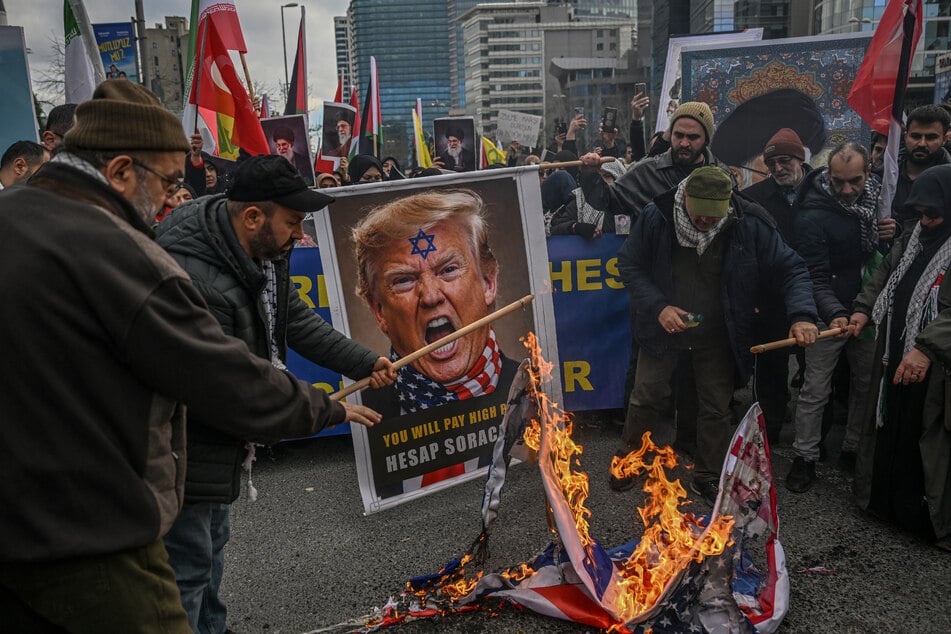 Protestors in Istanbul hold an image depicting Donald Trump set fire to a US flag as they gather to protest against the US and Israel's attack on Iran on March 1, 2026.
