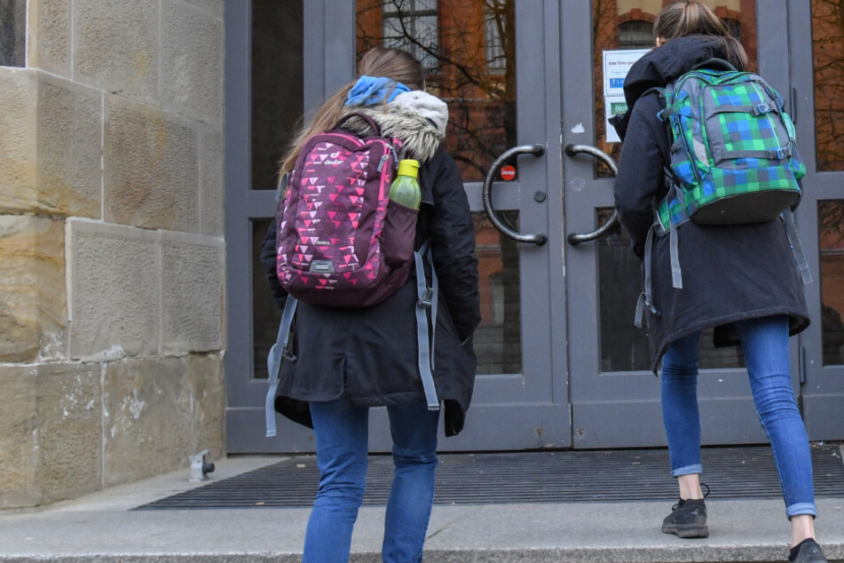Zwei Mädchen gehen am Montagmorgen zum Unterricht in ein Gymnasium.