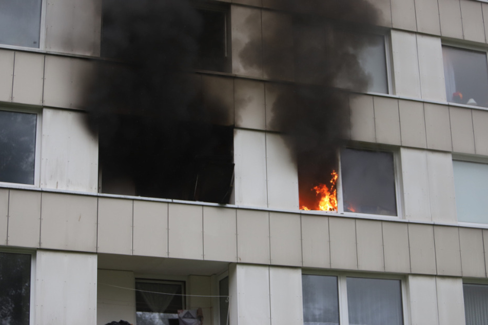 Flammen schlagen aus dem Hochhaus.