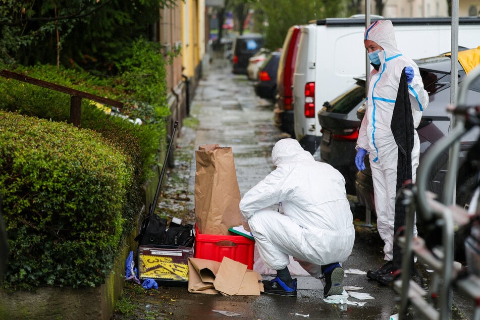 Beamte der Spurensicherung sichern nach dem Messerangriff Beweismittel auf einem Gehweg.