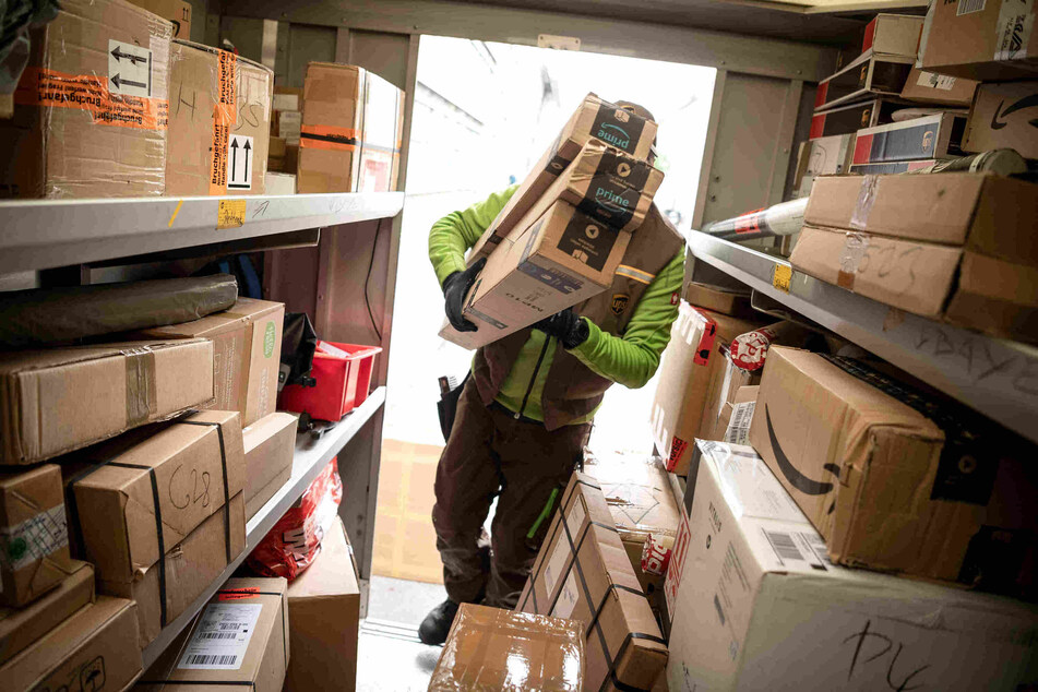 Ein Paketbote lädt Pakete in einen Transporter. (Symbolbild)