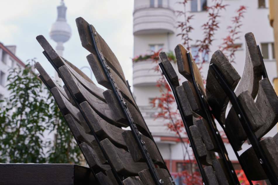 Unbenutzte Stühle der Gastronomie. Im Hintergrund der Berliner Fernsehturm.