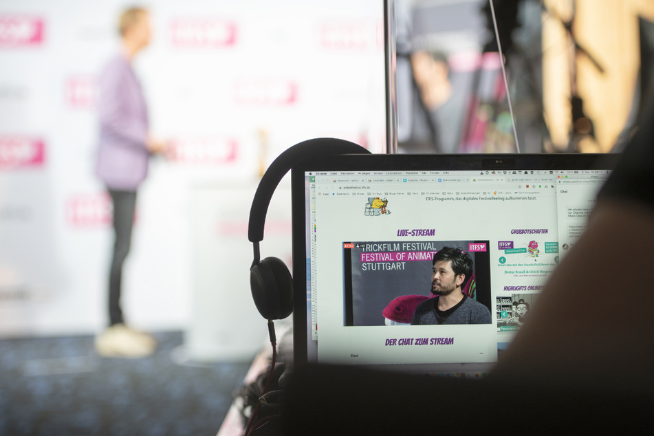Ein Zuschauer des Internationalen Trickfilm Festival und des Festival of Animation folgt 2020 einem Interview mit den Geschäftsführern auf der Bühne und dem Chat im Livestream über ein Laptop.