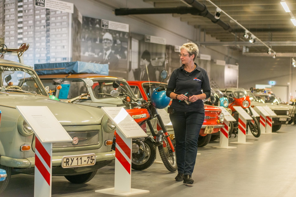 Noch-Museumsleiterin Gabi Reißig schreitet die Parade der Trabis und Mopeds ab.