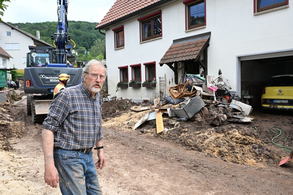 Werner Diggelmann steht vor Bergen von Abfall vor seinem Haus. Für ihn und viele andere Menschen beginnen nun die Aufräumarbeiten.