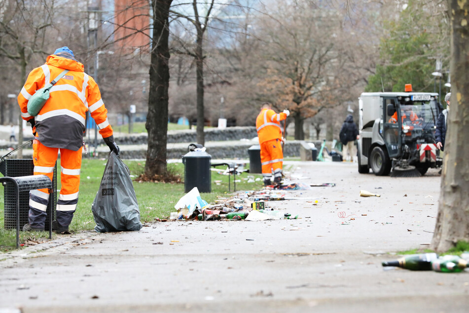 Mitarbeiter der AWB Köln entsorgen abgebrannte Feuerwerkskörper und anderen Müll am Fischmarkt in der Innenstadt.