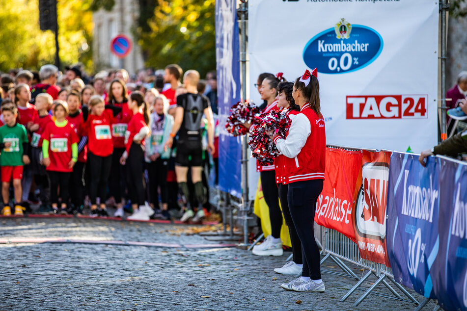 Cheeleader feuern die zielstrebigen Läufer und Walker an.