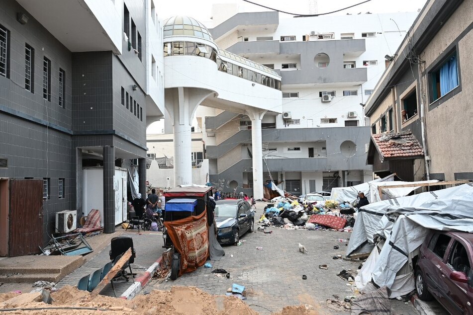 Palestinians gather outside one of the departments of the Al-Shifa hospital complex as Israel continues to drop bombs on Gaza.