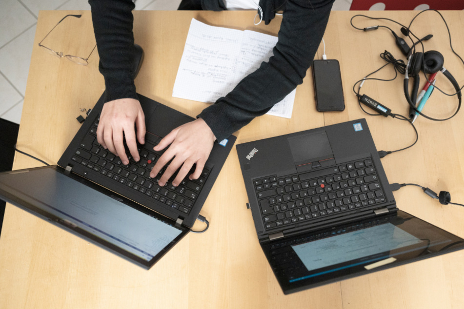 Eine Frau arbeitet im Homeoffice an ihren Laptops.