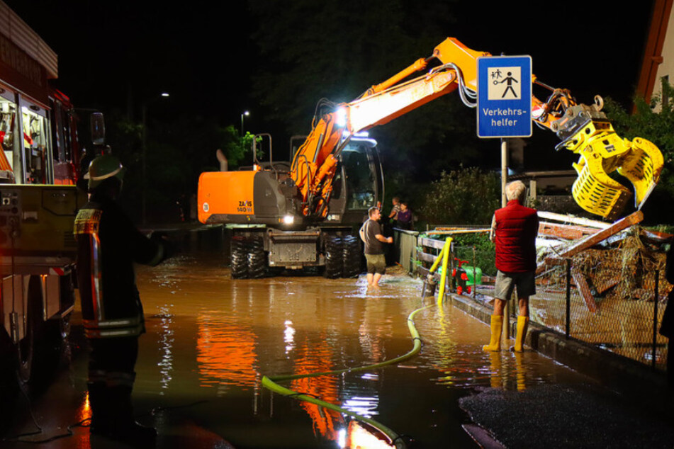 Feuerwehr und Helfer mit schwerem Gerät beseitigen Schäden nach schweren Unwettern in Ettenbeuren.