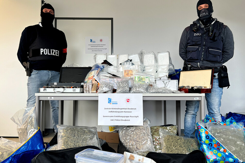 Zwei Ermittler der Ermittlungsgruppe Rauschgift (GER) stehen neben den beschlagnahmten Drogen.