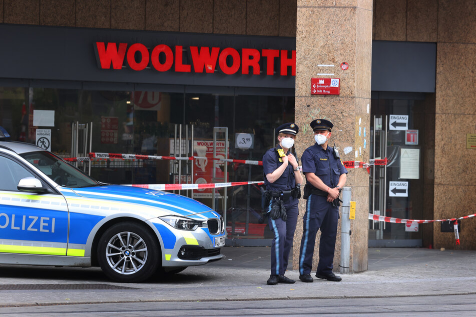 Polizeibeamte stehen vor der Filiale der Einzelhandelskette Woolworth, in der Innenstadt von Würzburg. Dort begann am Freitag das blutige Massaker.