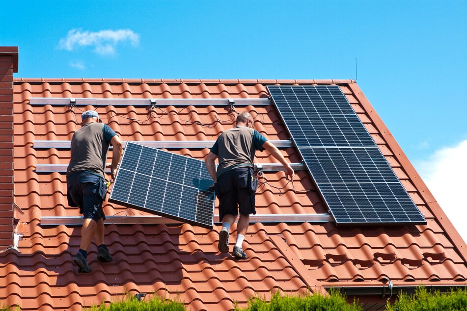 Handwerker installieren eine PV-Anlage auf dem Dach eines Einfamilienhauses. Die Investitions- und Kaufbereitschaft stagniert. Das spürt das Handwerk deutlich.