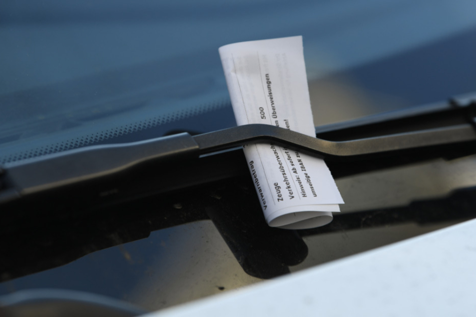 Teurer Liebesbrief. Ein Strafzettel klemmt an einem Auto.