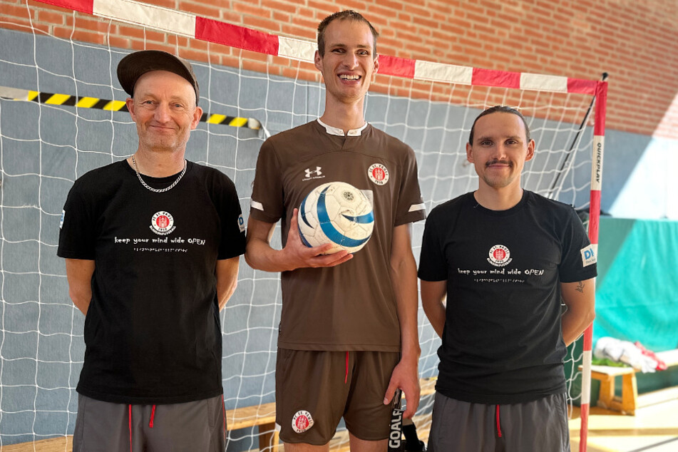 V.l.n.r.: Cheftrainer Wolf Schmidt (59), Nationalspieler Rasmus Narjes (24) und Co-Trainer Jonas David stellten das Projekt "CheckVoy!" in der Grundschule St. Pauli vor.