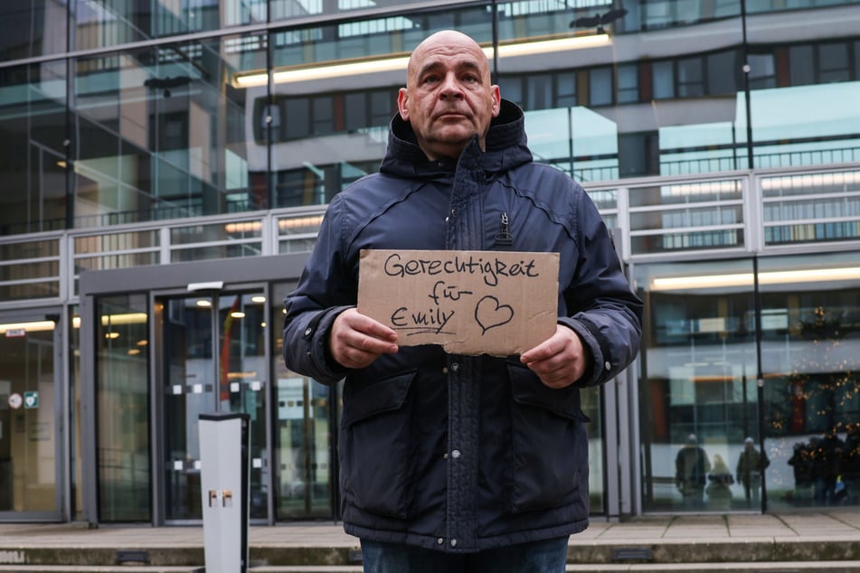 Kay Schierwagen hält bei der Mahnwache ein Schild mit der Aufschrift "Gerechtigkeit für Emily" hoch.