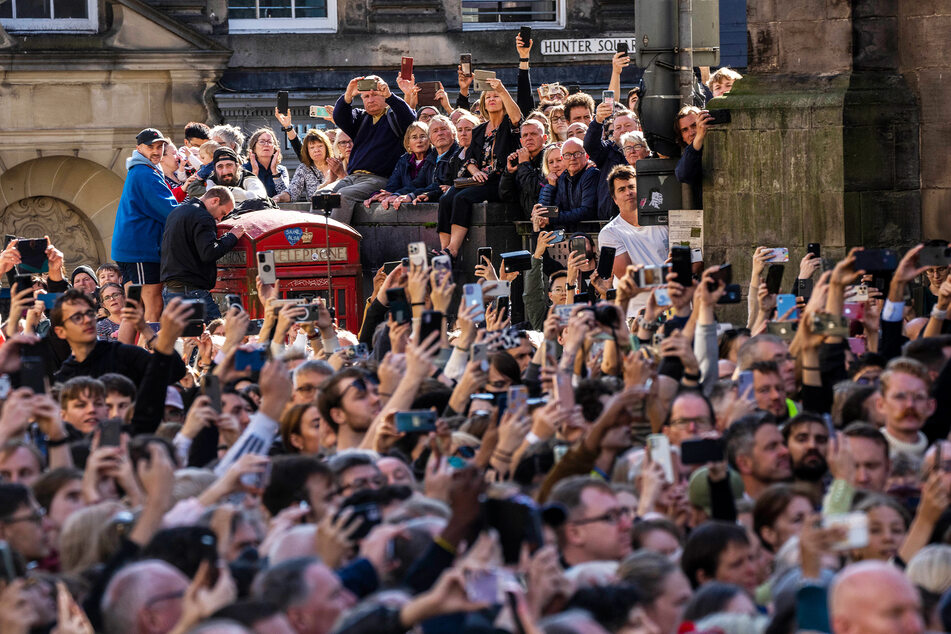 Menschen nehmen an der Prozession des Sarges von Königin Elizabeth II. vom Palace of Holyroodhouse zur St. Giles Cathedral auf der Royal Mile teil.