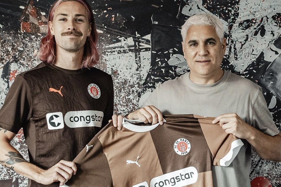 St. Pauli Sportchef Andreas Bornemann (52,r.) freut sich über die Verlängerung mit Kapitän Jackson Irvine.