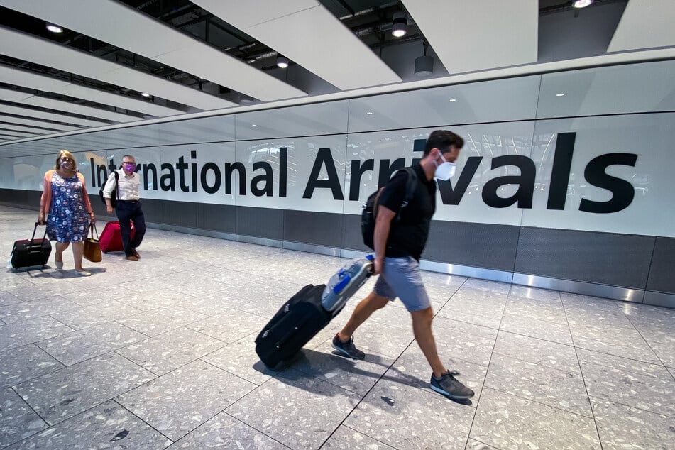 Passagiere gehen durch die Ankunftshalle des Londoner Flughafens Heathrow.