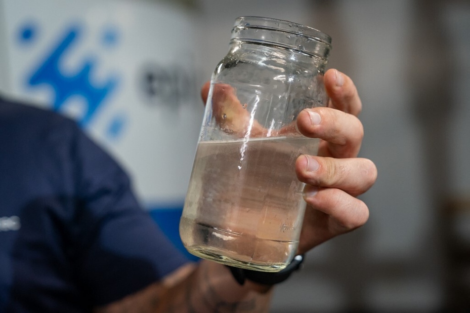 Ryan Pulley, director of water re-use operations for startup Epic Cleantec, holds up a sample of treated water in the basement of a downtown building where the company’s technology is used in San Francisco, California.