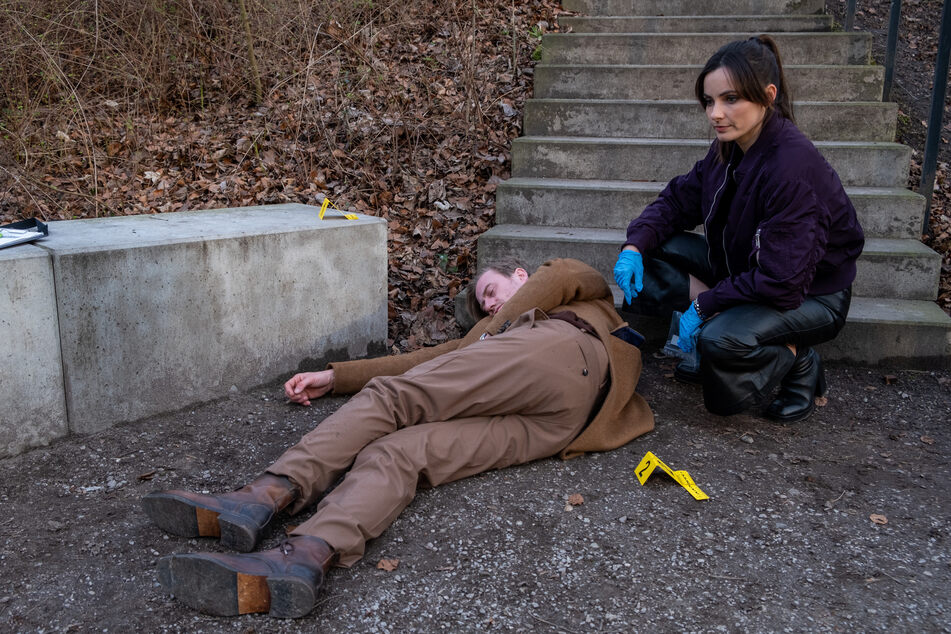 Franzi Berger (Paula Schramm, 34) untersucht die Leiche von Tom Bartels (Eric Bouwer, 39) im Park.