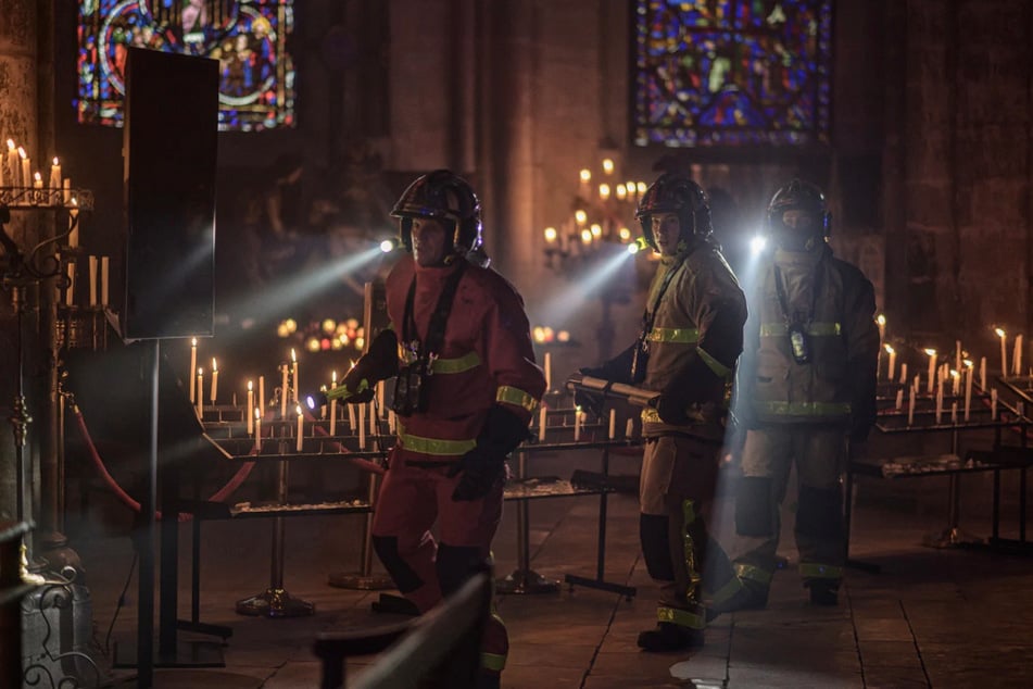 Feuerwehrleute wollen aus Notre-Dame kostbare Reliquien vor dem Feuer retten.
