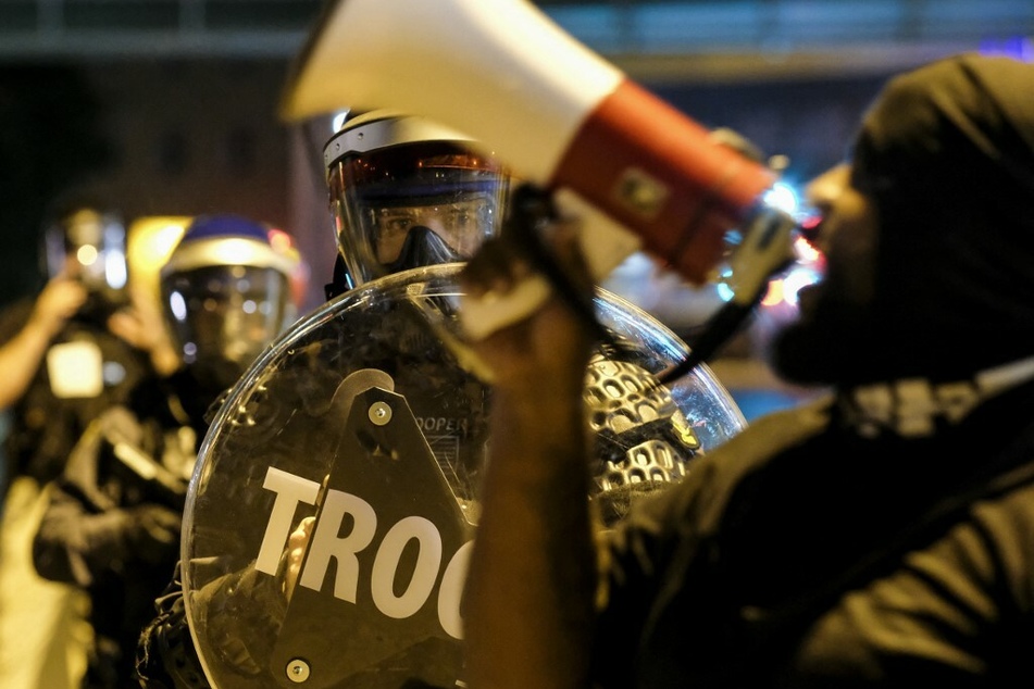 Troopers in riot gear watch as demonstrators gather to protest the killing of Jayland Walker, who shot by police on June 27 in Akron, Ohio.