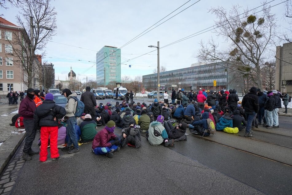 Zahlreiche Menschen haben eine Sitzblockade auf der Ostra-Allee errichtet.