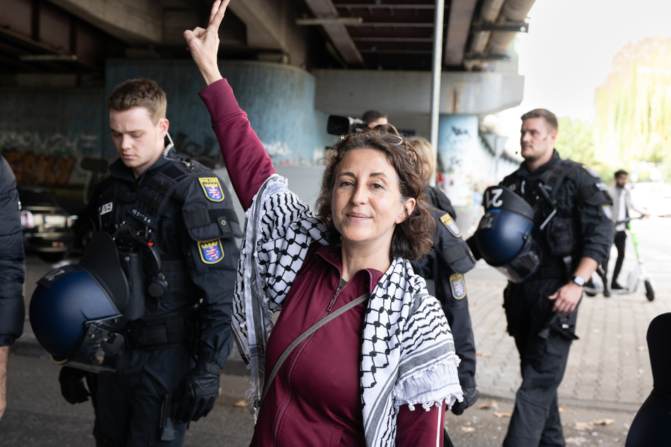 Die palästinensische Aktivistin Aitak Barani wird nach ihrer Festnahme von Polizisten abgeführt.