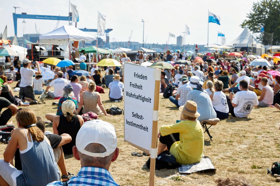 Ein Teilnehmer der Demonstration "Freiheit und Selbstbestimmung" auf der Reventlou-Wiese hält ein Transparent mit der Aufschrift "Frieden Freiheit Wahrhaftigkeit Selbstbestimmung".