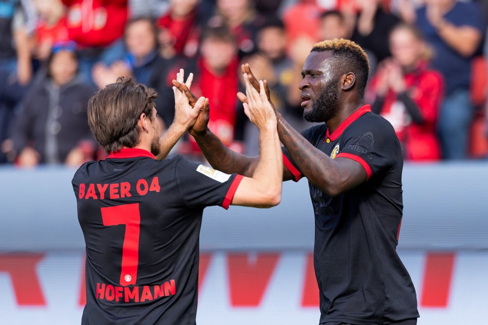 "Gib mir Fünf!" Die Bayer-Spieler um Jonas Hofmann (l.) und Victor Boniface (r.) hatten im Bundesliga-Heimspiel gegen Holstein Kiel in Hälfte eins noch alles im Griff. Dann kippte die Partie jedoch noch.