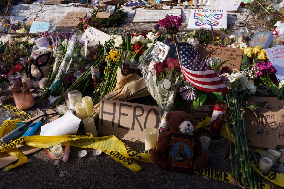 Flowers, candles, and signs are laid at a makeshift memorial for Alex Pretti in Minneapolis, Minnesota, on January 26, 2026.