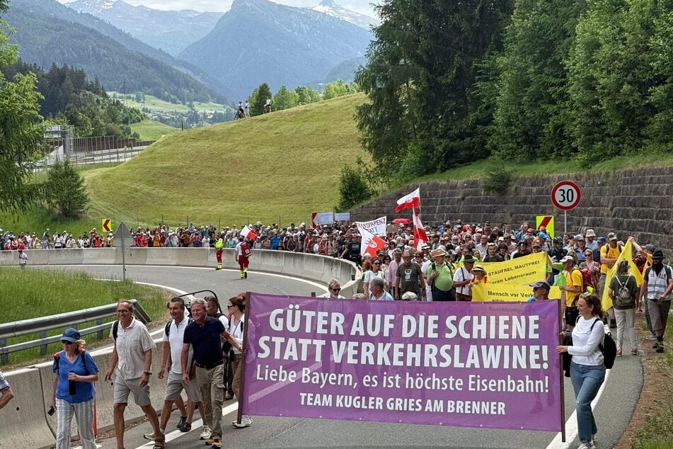 Teilnehmer der Demonstration protestieren mit Bannern und Plakaten gegen die Verkehrsflut am Brenner.