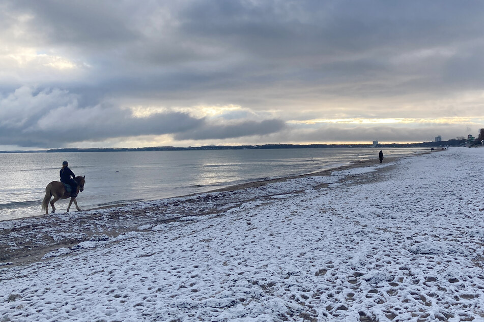 Ein Hauch von Winter an der Ostsee. Eine dünne Schneeschicht bedeckt den Strand.