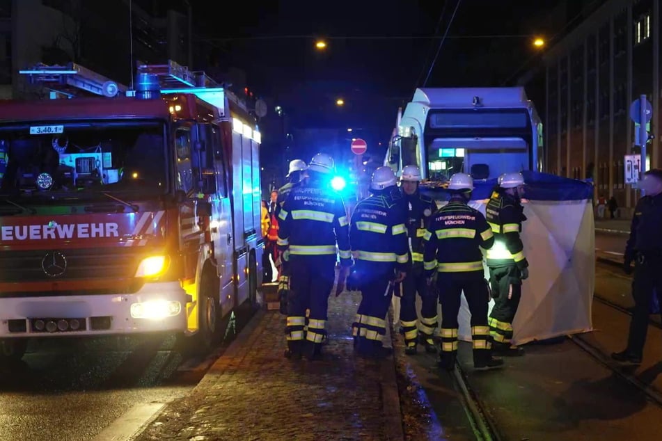 Die Feuerwehr München schirmt den das Unfallopfer ab.