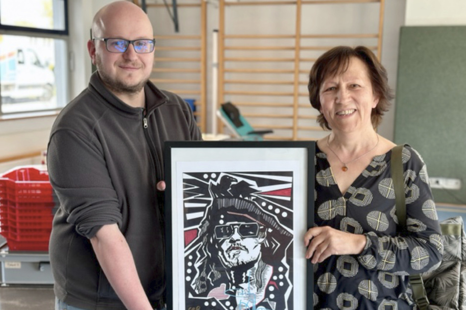 Isolde Bolduan (64) aus Hildburghausen bekommt von Andre Rehmer, Marketingreferent des Instituts für Transfusionsmedizin, den von Johnny Depp (59) signierten Kunstdruck überreicht.