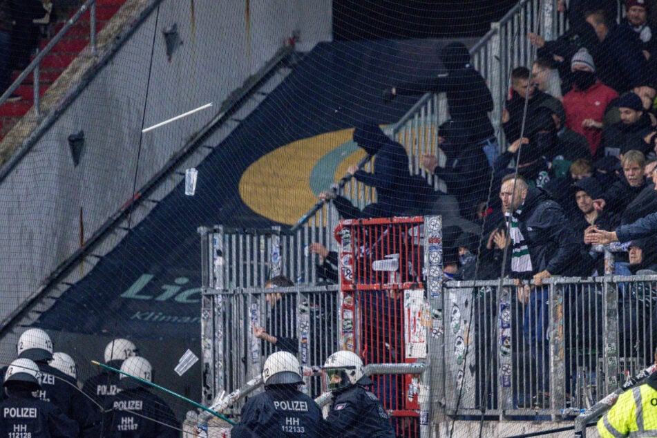 Polizisten werden von Hannover-Fans mit Gegenständen beworfen.