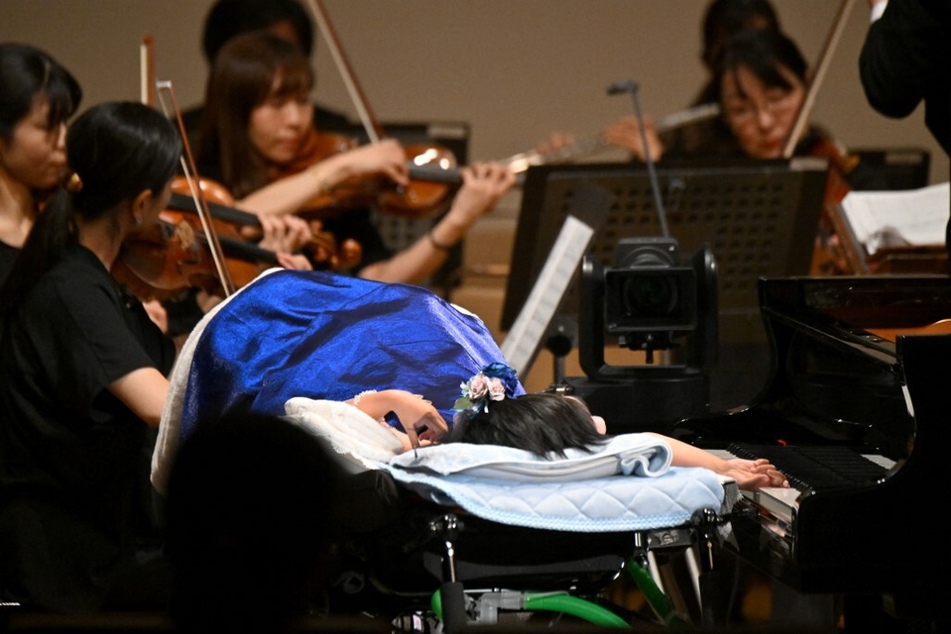Yurina Furukawa (front c.), who has a rare muscle condition called congenital myopathy and requires breathing assistance, plays an AI-powered piano during a Christmas concert rehearsal of Beethoven’s Symphony No. 9 with the Yokohama Sinfonietta orchestra in Tokyo, Japan.